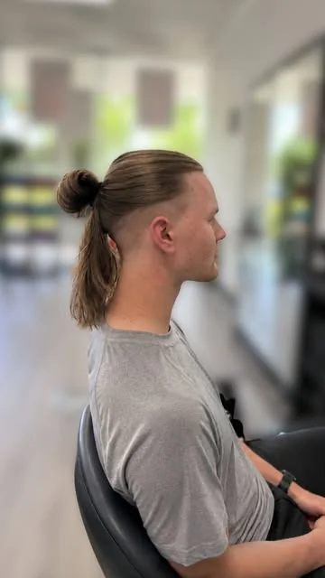 Men's undercut with a top knot, done at Artistic Trendz