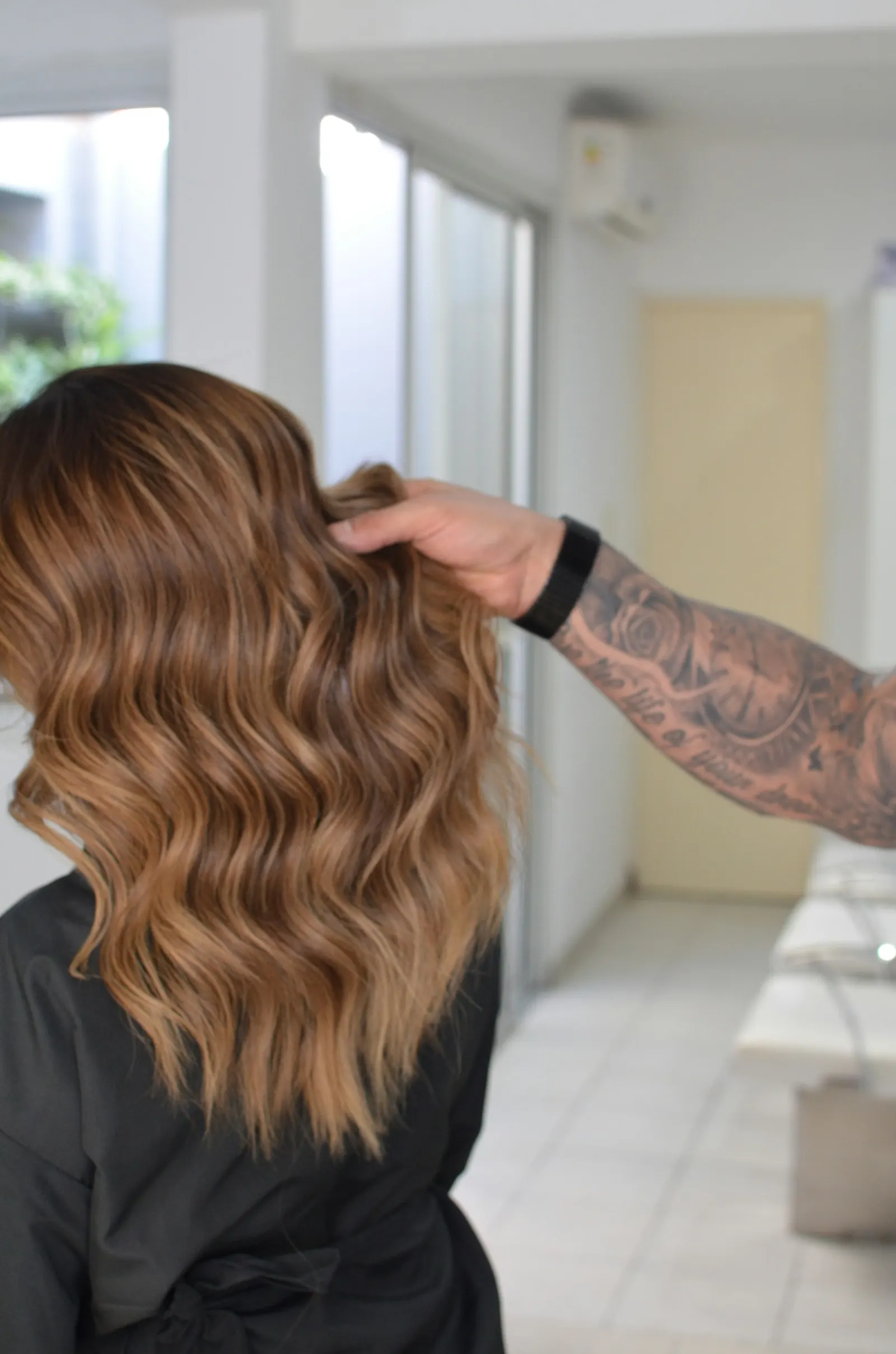 Stylist finishing loose waves on a client